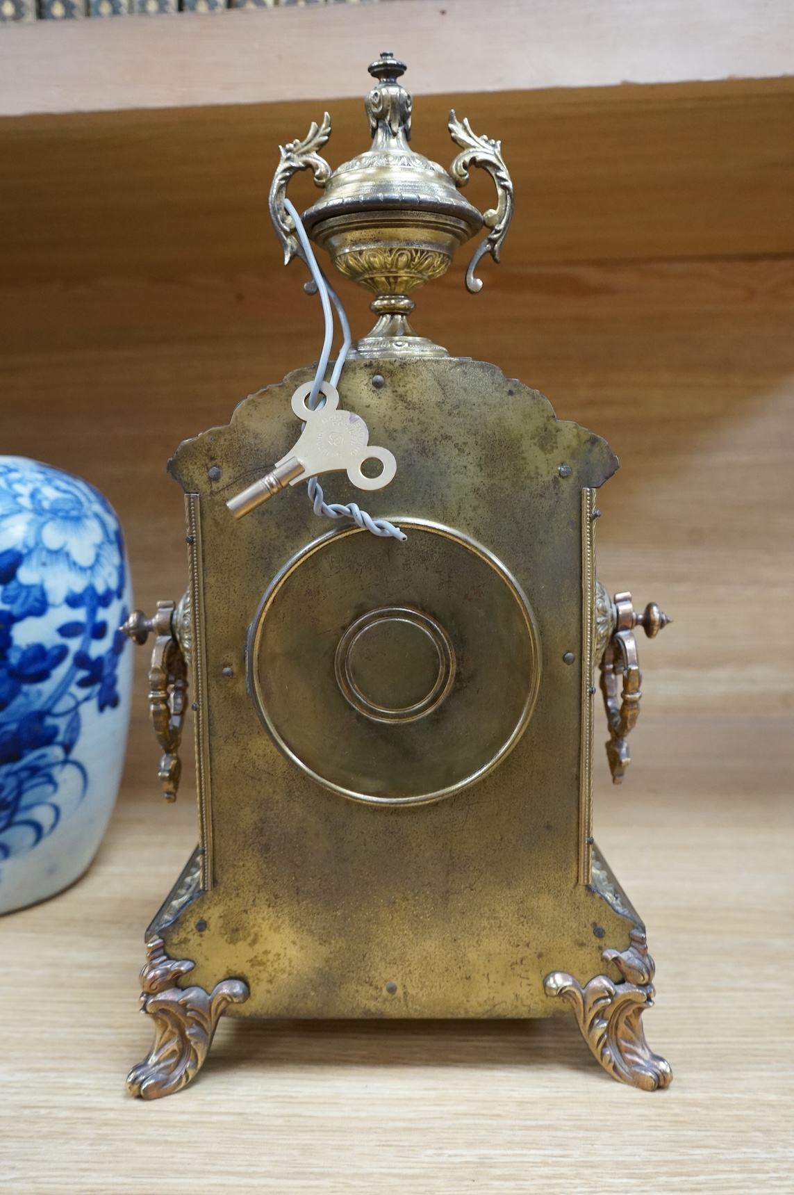 A decorative brass mantel clock with urn surmount, with 1st prize engraved panel, 41cm high